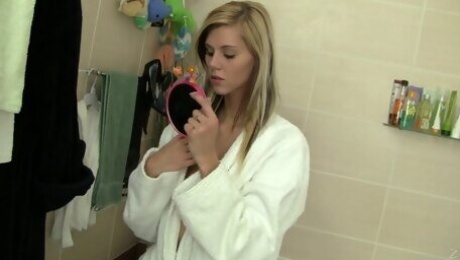 Slim blonde Sindy Vega plays with her shaved pussy in a bathroom